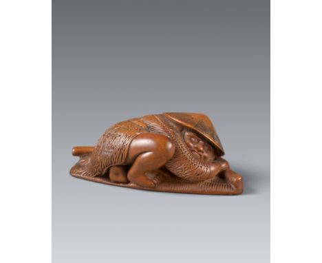 Netsuke eines Ronin, als Bauer getarnt. Buchsbaum. 19. Jh.Kauernd auf einer Strohmatte, der Körper ganz bedeckt von einem Bas