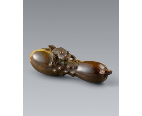 Netsuke eines Froschs auf einem Schwammkürbis. Grün und braun gefärbtes Elfenbein. Spätes 19. Jh.Sign.: GetchuÜber den hechim