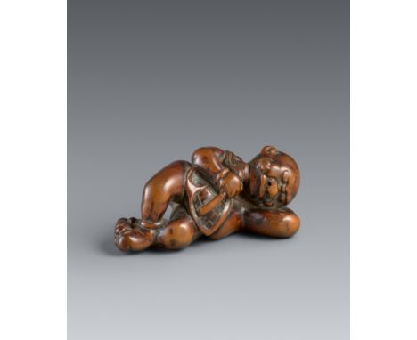 Netsuke eines liegenden oni. Buchsbaum. Frühes 19. Jh.Liegend, den Kopf auf den Arm aufgestützt, die Füße überkreuz, in den H
