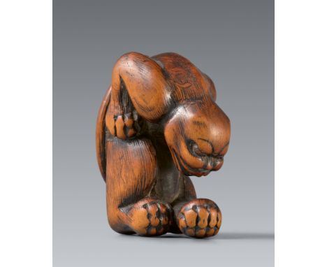 Netsuke eines Tigers. Buchsbaum. Kyoto. Spätes 18. Jh.Auf den Hinterflanken sitzend, den Körper mit angezogenen Vorderbeinen 