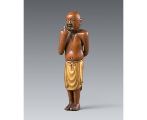 Netsuke eines stehenden Insulaners. Buchsbaum und Lack. 19. Jh.Mit eng zusammengestellten Füßen stehend, der Schurz aus Goldl