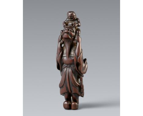 Netsuke eines sehr großen Shoki und oni. Holz. 18. Jh.Stehend mit mächtigen Stiefeln an den Füßen, hält Shoki die beiden Bein