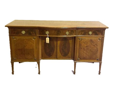 A Georgian style mahogany sideboard, with central bow drawer and niche with two cabinet doors, flanked by further drawers and