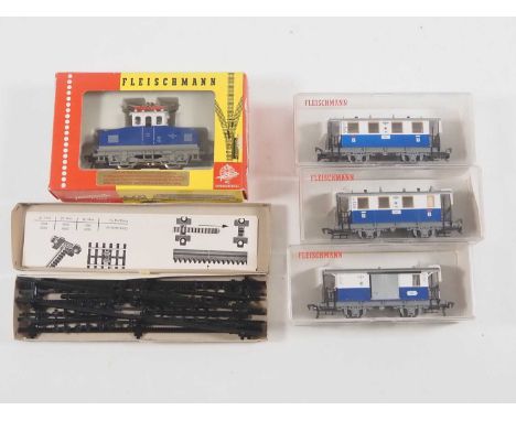 A FLEISCHMANN HO gauge 4306 rack railway electric locomotive together with a matching rake of three coaches and a box of rack