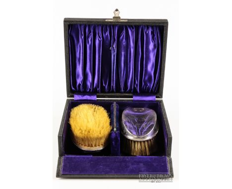 A set of two silver backed brushes, with a silver mounted comb, makers marks worn, Birmingham 1899, in fitted case