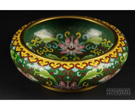 A Chinese cloisonne enamel bowl, circular with everted rim, decorated with pink lily flowers on a dark green ground within a 