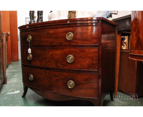 A Victorian mahogany bow fronted chest of three long drawers, pull-out writing surface, ring handles, raised on shaped feet, 