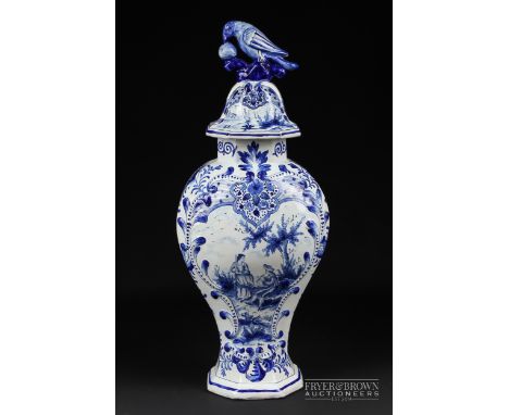 A large Dutch delftware blue &amp; white vase and cover, moulded with a foliate mirror shaped reserve and painted with a scen