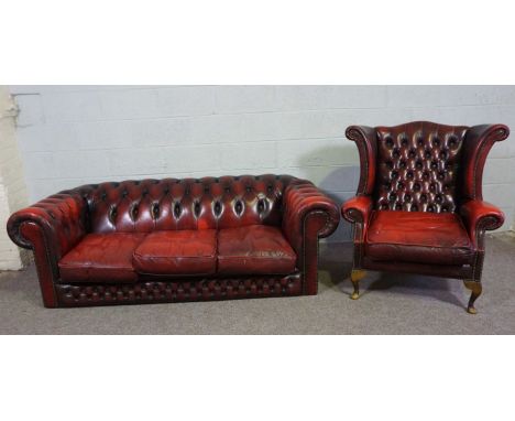 A Chesterfield three seat sofa, and similar armchair, both button upholstered in ox-blood 'leather' (2)