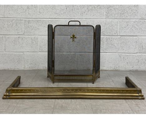 An early 20th century iron meshwork fireguard with an applied Fleur de Lys crest raised on a brass openwork base along with a