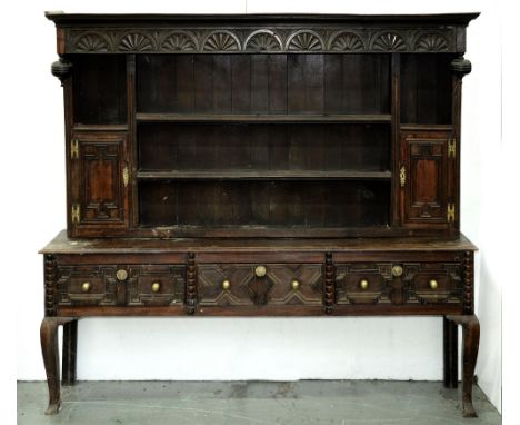 An oak dresser, 19th c, the associated boarded rack with turned pendants and lunette frieze, spice cupboards with geometric d