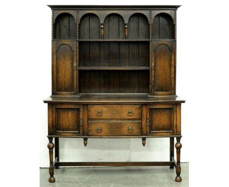 An oak dresser, c1930, the boarded rack with spice cupboards, 200cm h; 55 x 151cm  Top somewhat scratched