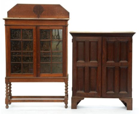An oak bookcase, early 20th c, with four panel doors, on bracket feet, 110cm h; 26 x 90cm and an oak bookcase with glazed doo