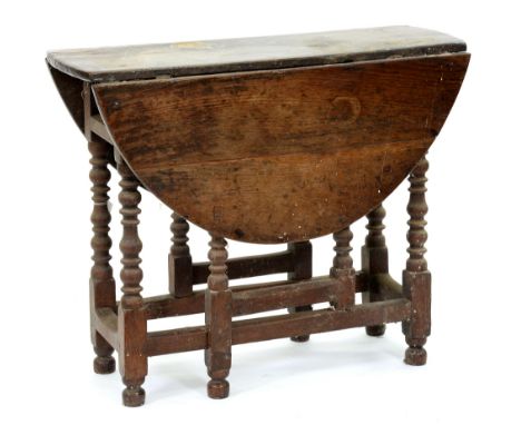 A George II oak gateleg table, with bobbin turned legs, 75cm h; 91 x 107cm  Much encrusted with old dirt, dust and birdlime, 