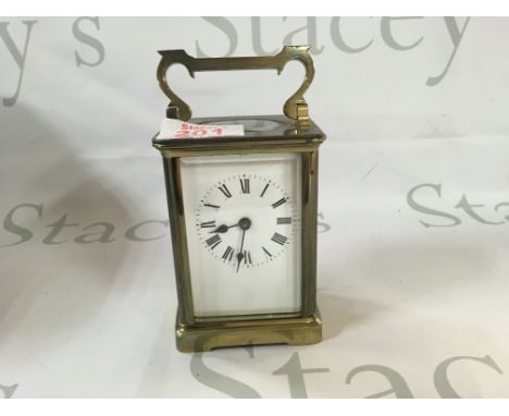 A Victorian antique clock made from brass which has Roman numerals and a visible mechanism.