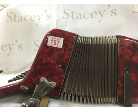 Piano accordion by Worldmaster Foreign. Red, white and gold and is roughly 46 cm wide and 18cm tall.
