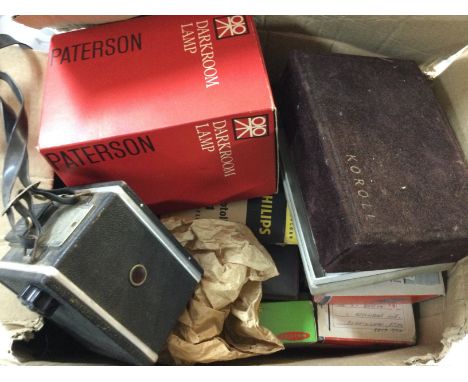 A collection of cameras, one is a vintage box camera and the other is a camera by Koroll and a collection of colour slides an