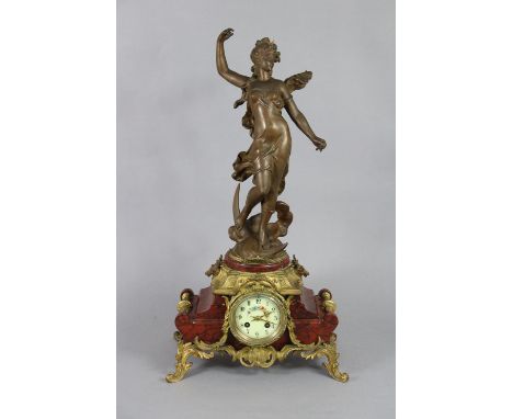 A Victorian mantel clock in gilt-metal &amp; rouge marble case with painted dial, speltre figure of “Diana” standing above, 1