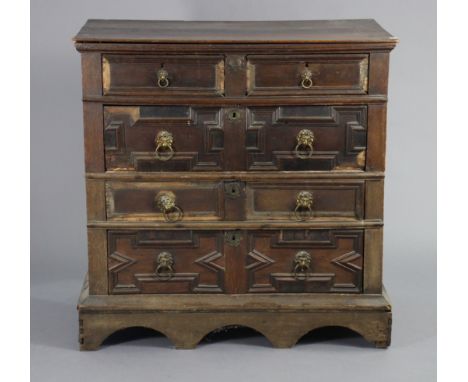 A 17th century oak chest with&nbsp;&nbsp;applied mouldings, in two sections, fitted two short &amp; three long graduated draw