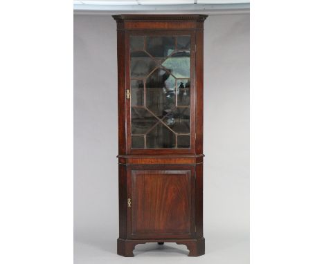 A Georgian mahogany corner cabinet with dentil cornice above three fixed shelves enclosed by an astragal glazed door with a f