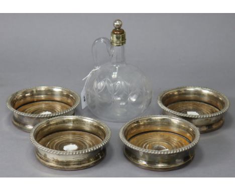 A set of four silver-plated wine coasters inset turned wood bases; &amp; a clear cut-glass ovoid wine flask with plated mount