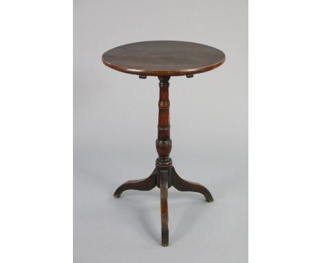 A late 18th/early 19th century oak finish table, the 18” circular tilt-top on ring turned centre column &amp; curved legs, 27