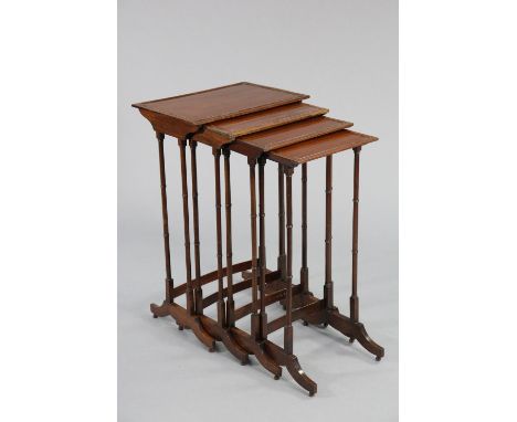A nest of four regency mahogany occasional tables with rectangular tops on slender ring-turned legs with shaped end supports 