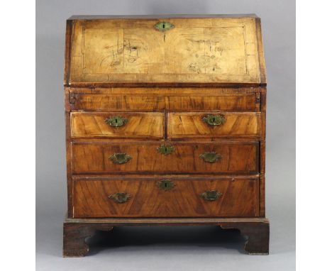 A George I figured walnut &amp; feather-beaded bureau, the sloping fall-front enclosing fitted interior with well compartment
