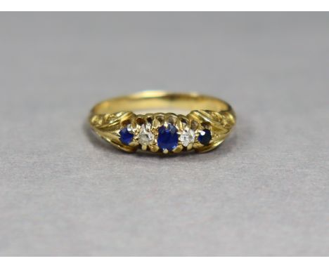 An 18ct gold ring set three small oval sapphires with two small diamonds in between, size K, weight 3.2g.