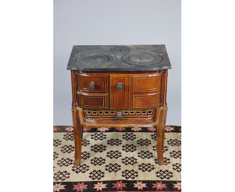 An early 20th century cast iron wood burning stove made by MONTHERME of France, enamelled in light brown, on tall tapering le