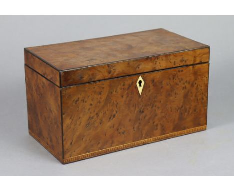 An early 19th century burr-yew wood veneered three-division tea caddy, of plain rectangular form with ebonised stringing &amp
