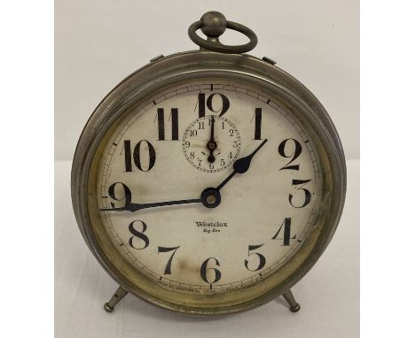 A 1920's metal cased Westclox Big Ben alarm clock with white face.  Raised on 2 period style screw-in feet with central suppo