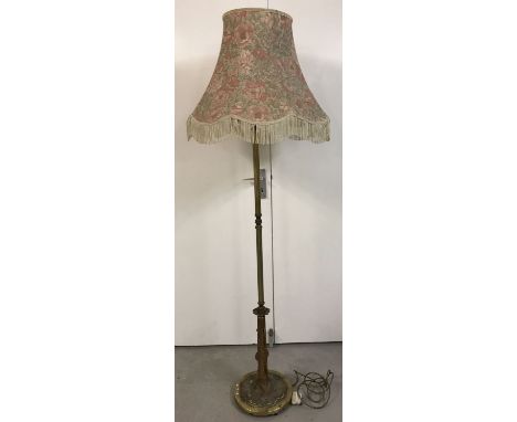 A brass covered standard lamp with Art Nouveau style lotus flower and leaf design to base.   Total height without light shade