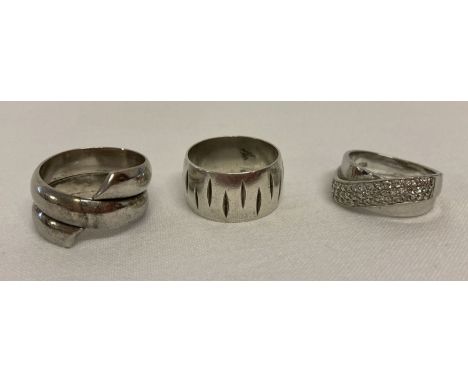 3 silver band style dress rings.  A spiral design, a twisted band set with clear stones and a vintage band with vertical line