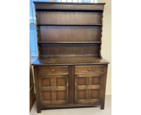 An Ercol style dark wood dresser with 2 drawer,  2 door cupboard base. Shaped top with 2 shelves.  One drawer for cutlery wit