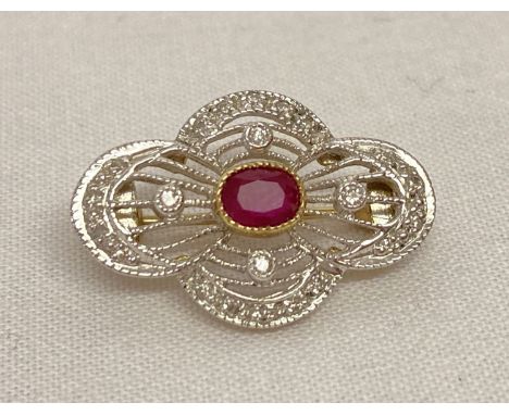 An Art Deco style, open pierced work design gold brooch, set with diamonds and a central ruby. Hallmarks to back of brooch an