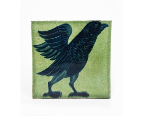 A William De Morgan tile, painted with a bird standing and flapping its wings, in blue on a green ground, impressed factory m