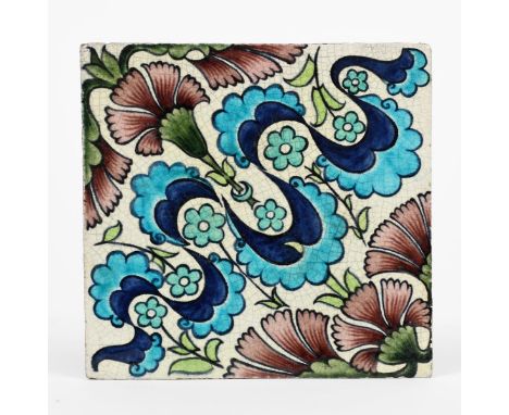 A William De Morgan Late Fulham Period Persian tile, painted with carnation flowers in blue, turquoise, aubergine and green o