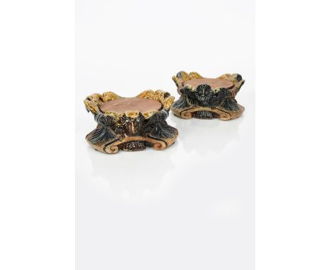 A rare pair of Martin Brothers grotesque stoneware stands by Robert Wallace Martin, low tripod foot with flaring foliate pane