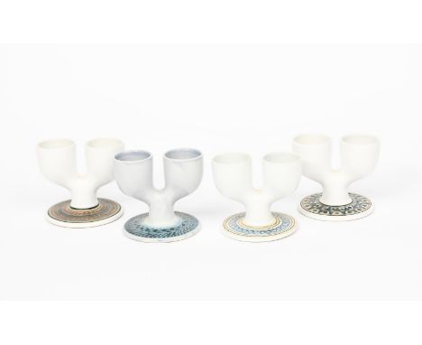 Four Troika Pottery Double Egg Cups,  each resist decorated to the foot in blue, black and ochre on a white ground, painted T