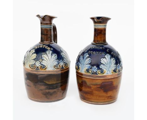 A pair of Doulton Lambeth stoneware water jugs, one titled Scotch the other Grant Mackay &amp; Cos Scotch, both modelled in l