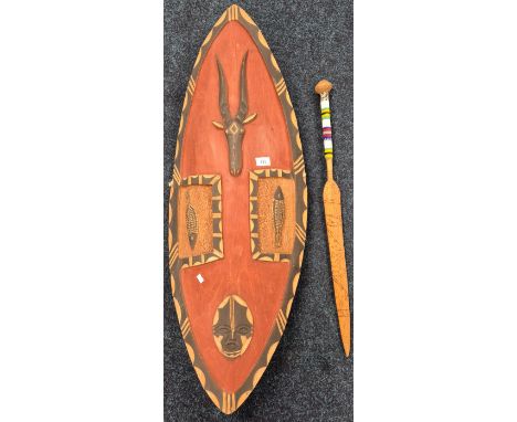 Large African tribal carved shield along with a ceremonial sword decorated with beadwork handle. 101cm length of shield. 