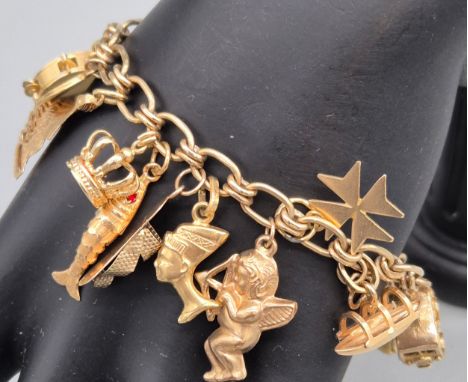 9ct yellow gold charm bracelet fitted with 20 charms. Sarcophagus, tambourine, Log cabin, Horse box van and others. 40grams.