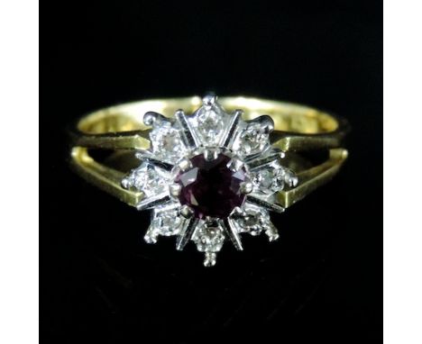 An 18 carat gold ruby and diamond cluster ring, boxed