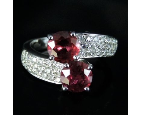 An 18 carat white gold ruby and diamond crossover ring