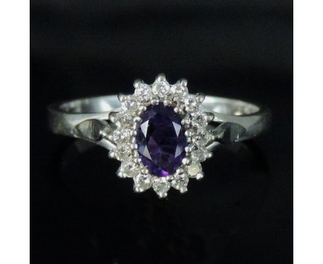 An 18 carat white gold amethyst and diamond cluster ring, boxed