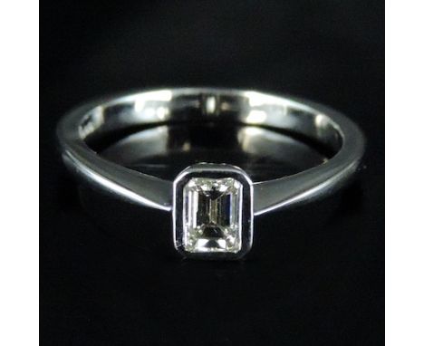 An 18 carat white gold and diamond emerald cut single stone ring