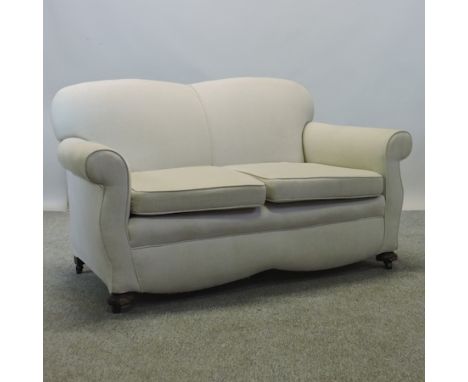 A 1920's cream upholstered two seater sofa, 138cm