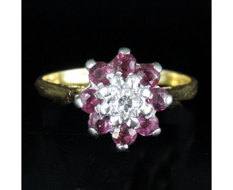 An 18 carat gold ruby and diamond cluster ring, boxed