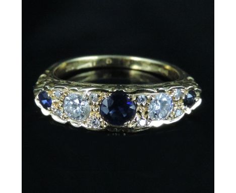 An 18 carat gold sapphire and diamond five stone carved ring